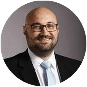 Man with glasses and a beard smiling